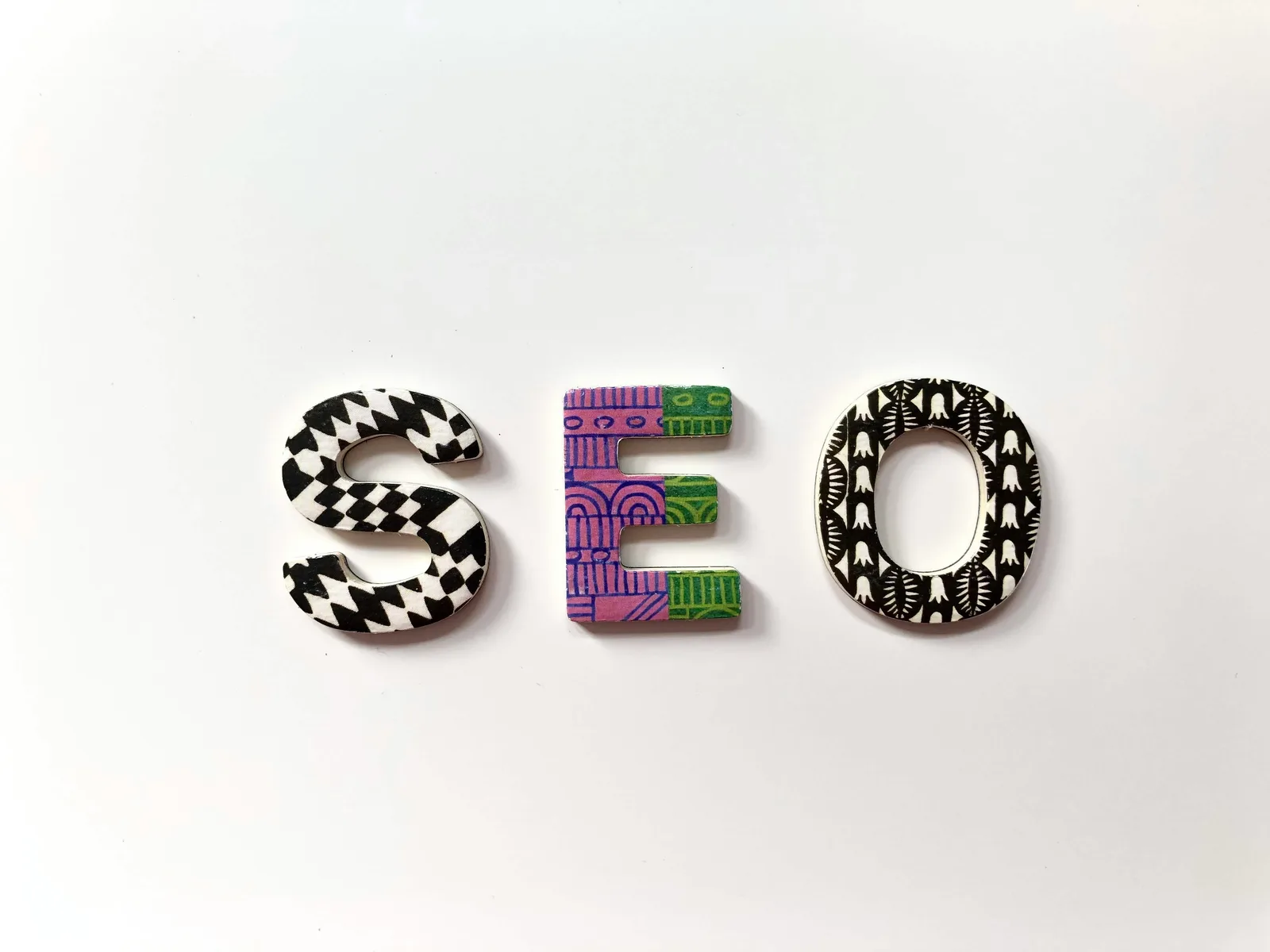 Colorful decorative letters spelling 'SEO' on a white background; visual concept representing search engine optimization and AI-driven digital visibility.