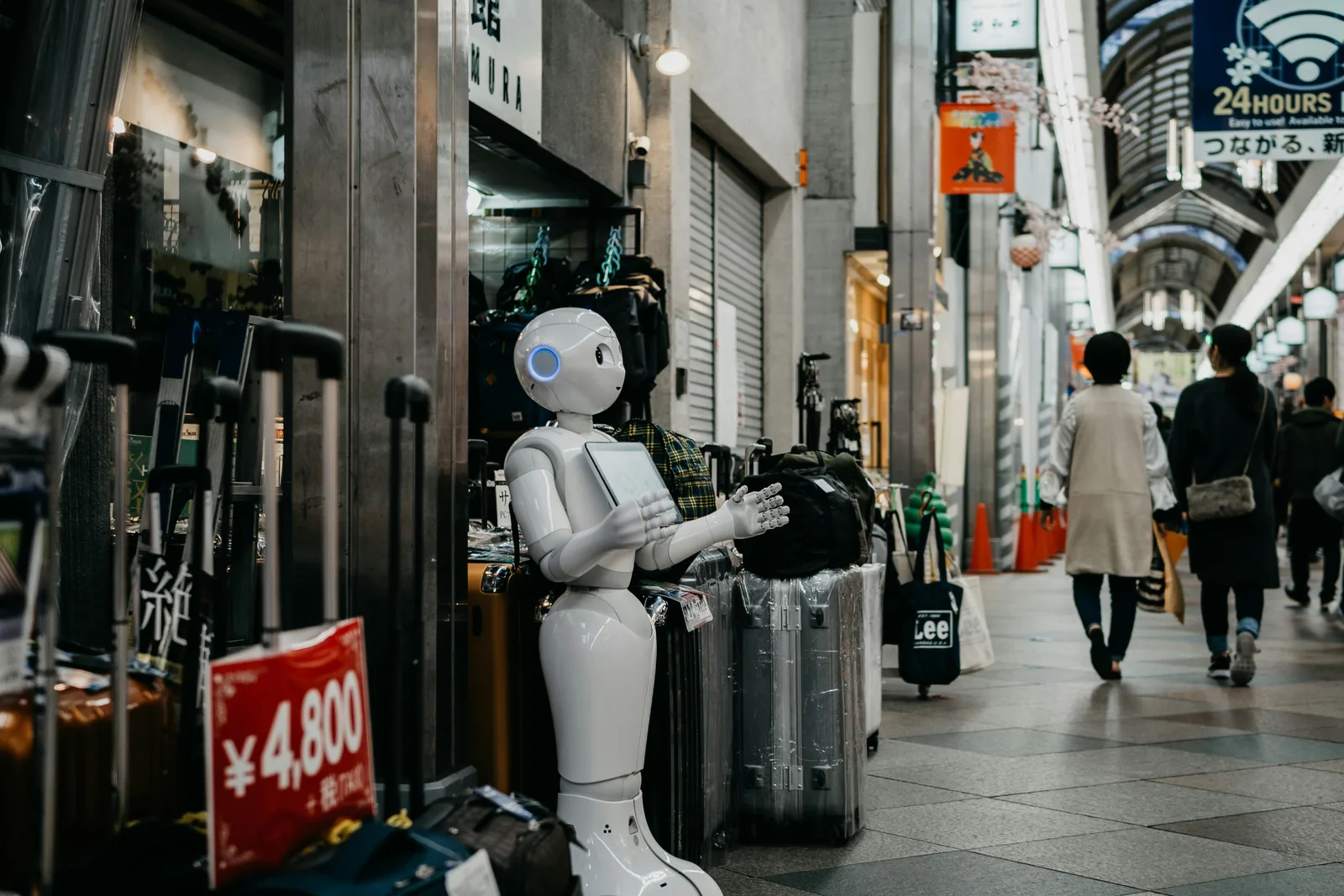 Humanoid robot engaging with shoppers in a busy market, illustrating AI technology and automation in real-world environments for AI SEO insights.
