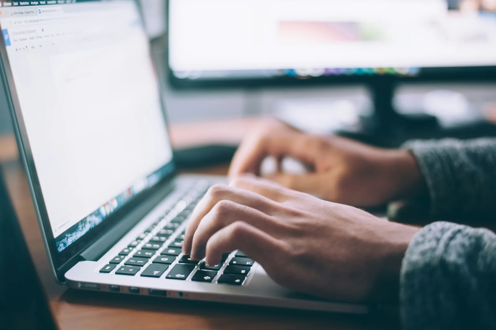 Person typing on a laptop while researching how many articles should I post for AI SEO, illustrating the process of creating consistent online content.