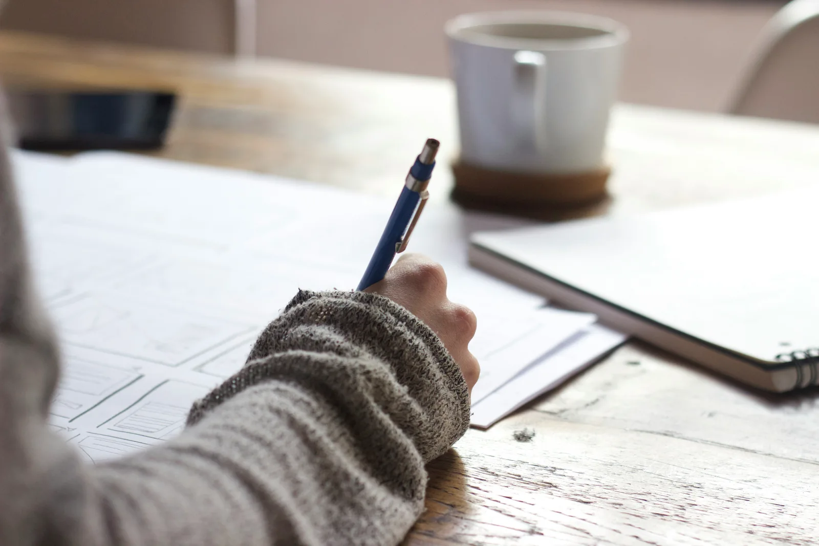 Writer jotting down ideas and outlining topics related to how many articles they should post for AI SEO, showing early-stage content planning.